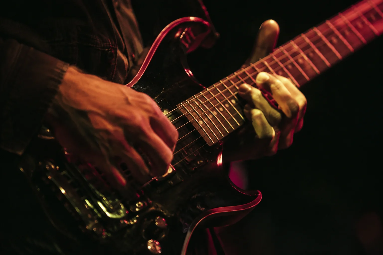 Illustrative close-up of a musician’s hands on a guitar